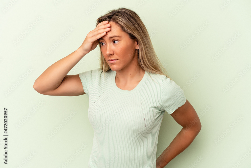 Young caucasian woman isolated on green background having a head ache, touching front of the face. Young caucasian woman isolated on green background having a head ache, touching front of the face.