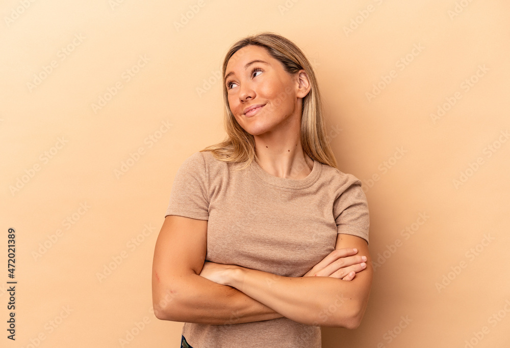 Obraz premium Young caucasian woman isolated on beige background dreaming of achieving goals and purposes