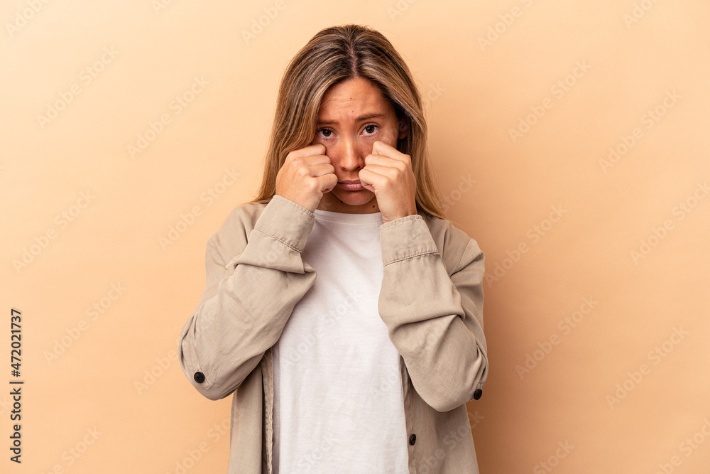 Young caucasian woman isolated on beige background whining and crying disconsolately. Young caucasian woman isolated on beige background whining and crying disconsolately.