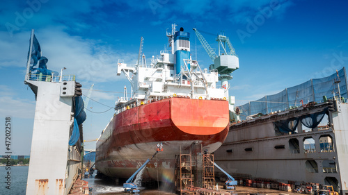 Bild auf Leinwand The hull painting consists of washing, blasting and painting of the vessel cargo ship by operator at international dry dock concept maintenance service annual cleaning