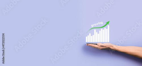 Male hand holding smart mobile phone with graph icon.checking analyzing sales data growth graph chart and stock market on global networking. Business strategy, planning and digital marketing