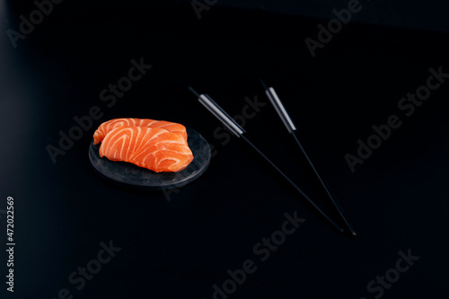 various salmon sushi on a black plate