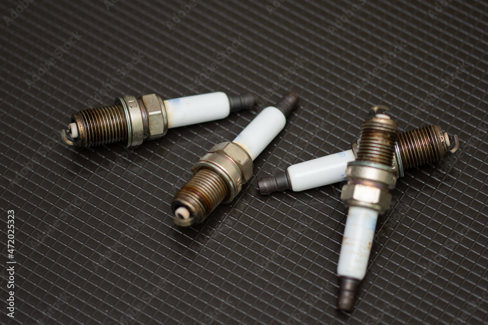 Set of car spark plugs on a black background Set of car spark plugs on a black background