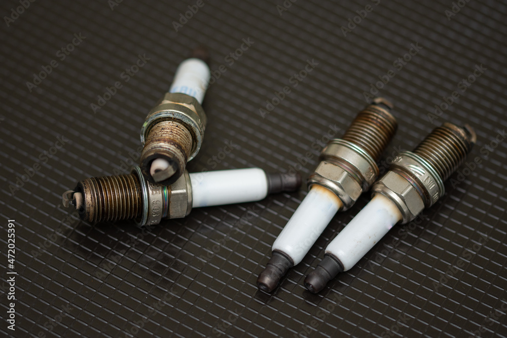 Set of car spark plugs on a black background Set of car spark plugs on a black background