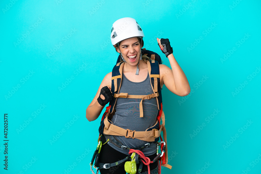 Young Italian rock-climber woman isolated on blue background celebrating a victory