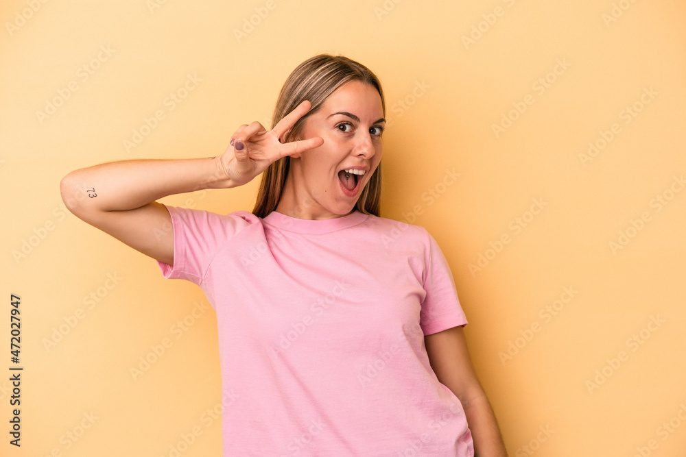 Young caucasian woman isolated on yellow background dancing and having fun.