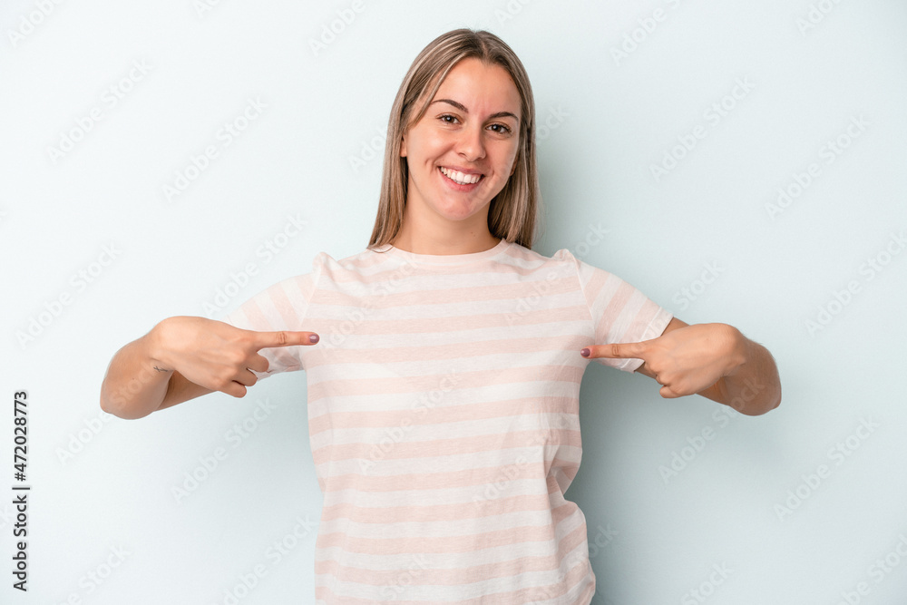 Young caucasian woman isolated on blue background points down with fingers, positive feeling. Young caucasian woman isolated on blue background points down with fingers, positive feeling.
