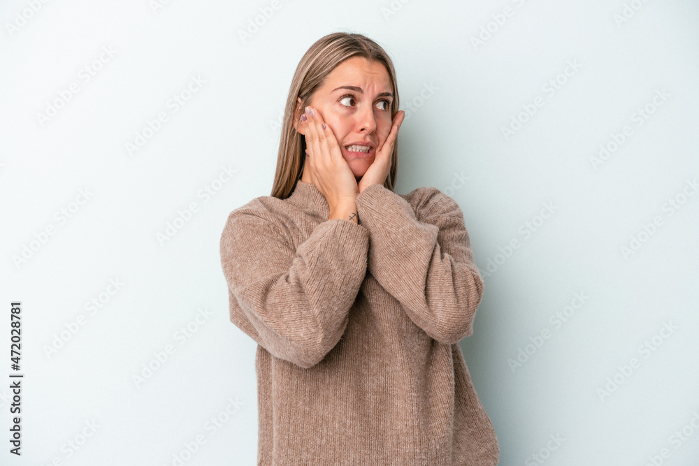 Young caucasian woman isolated on blue background scared and afraid. Young caucasian woman isolated on blue background scared and afraid.