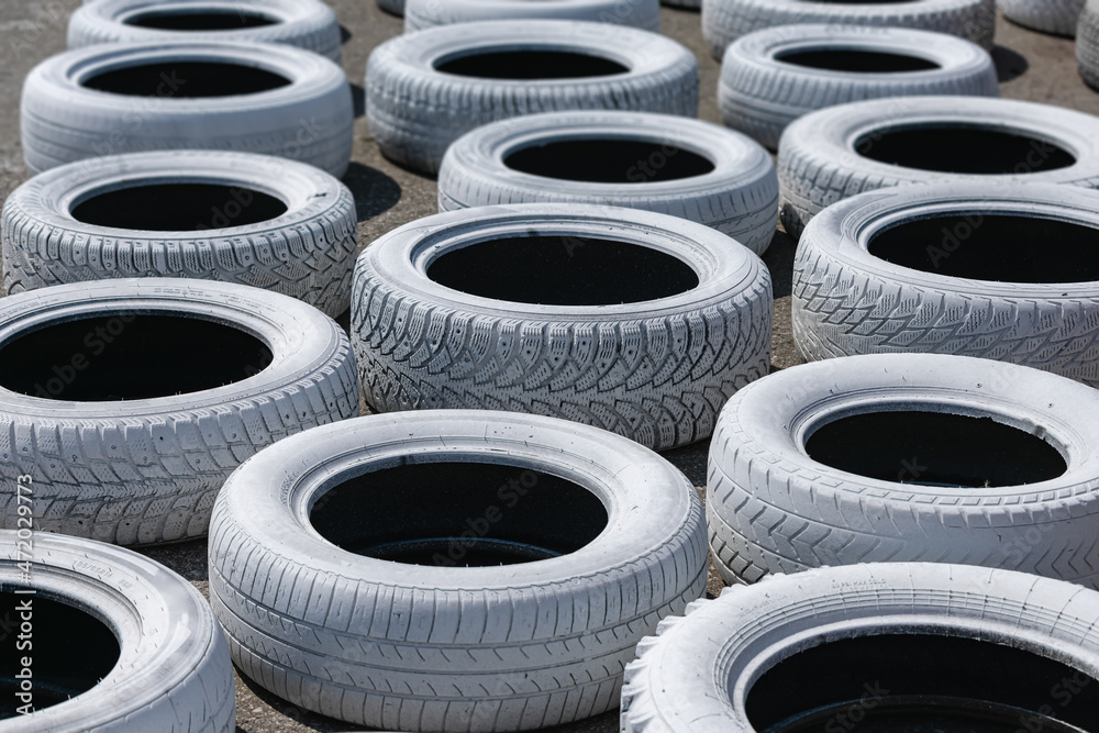 Old used car tires, painted bright white and installed on the race track for safety Old used car tires, painted bright white and installed on the race track for safety