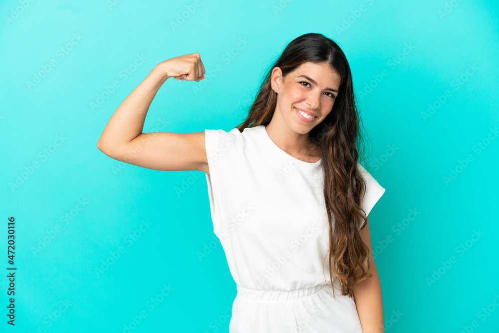 Fototapeta premium Young caucasian woman isolated on blue background doing strong gesture