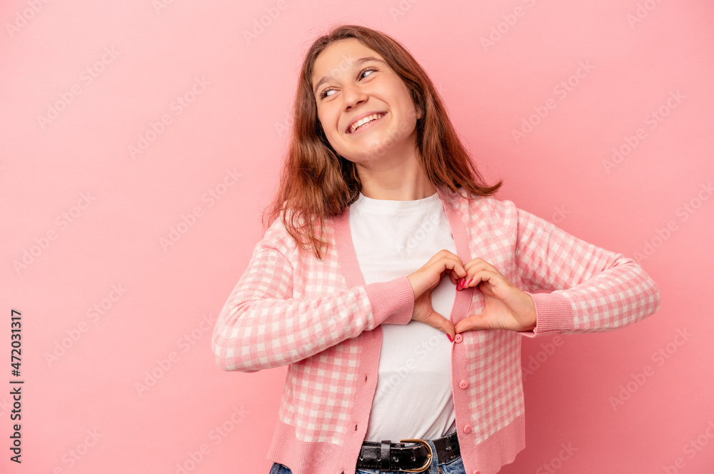 Little caucasian girl isolated on pink background smiling and showing a heart shape with hands. Little caucasian girl isolated on pink background smiling and showing a heart shape with hands.