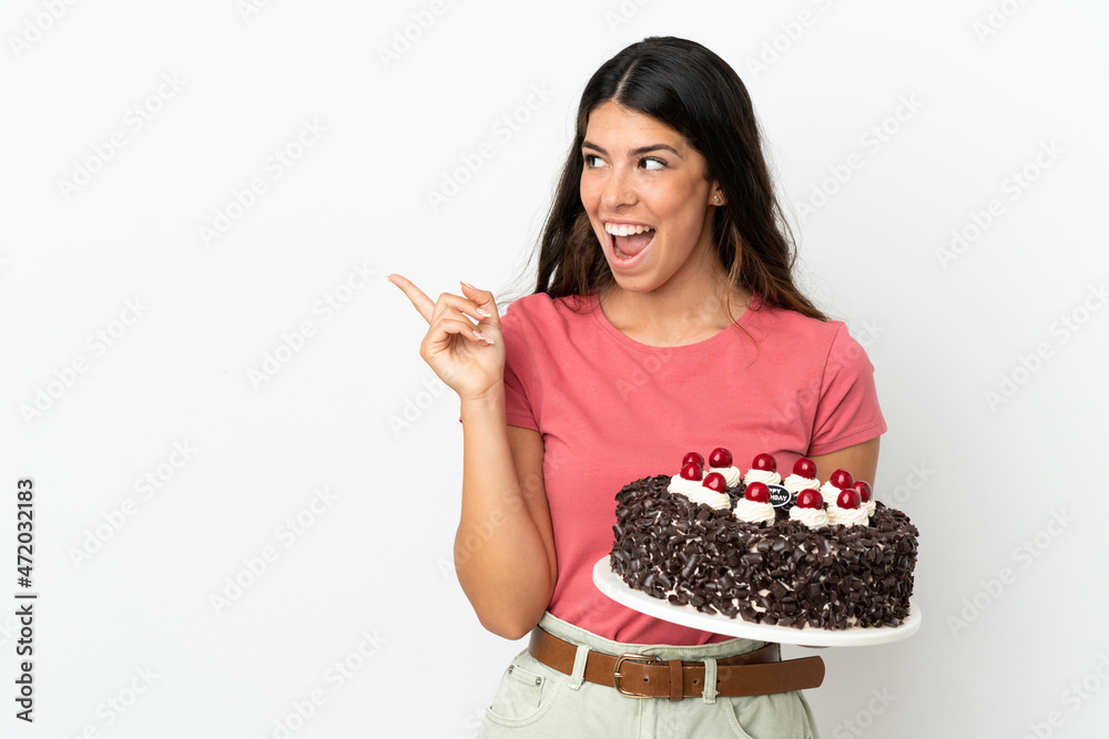 Young caucasian woman holding birthday cake isolated on white background intending to realizes the solution while lifting a finger up Young caucasian woman holding birthday cake isolated on white background intending to realizes the solution while lifting a finger up