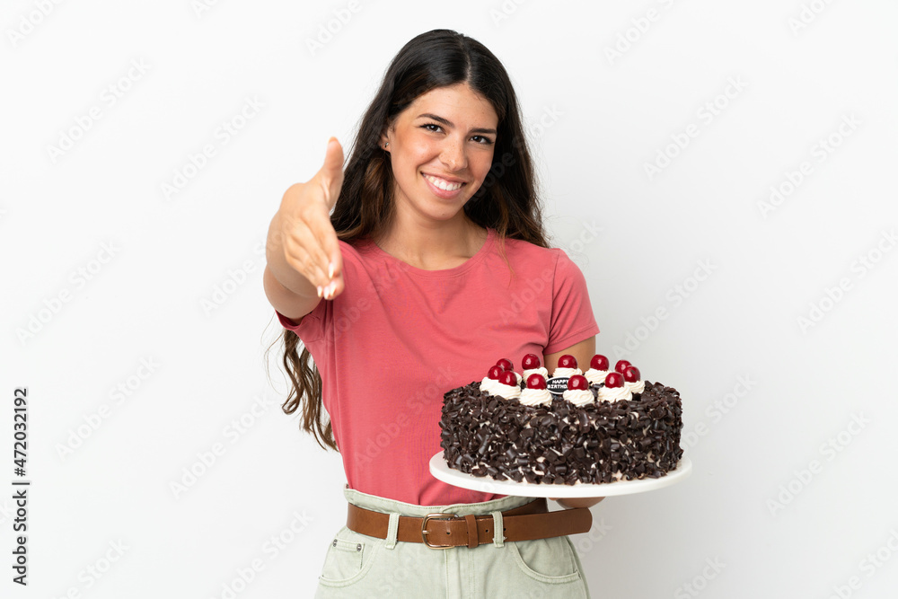 Young caucasian woman holding birthday cake isolated on white background shaking hands for closing a good deal Young caucasian woman holding birthday cake isolated on white background shaking hands for closing a good deal