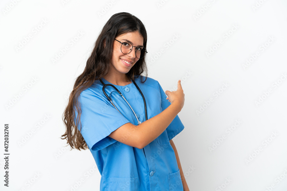 Young surgeon doctor caucasian woman isolated on white background pointing back Young surgeon doctor caucasian woman isolated on white background pointing back
