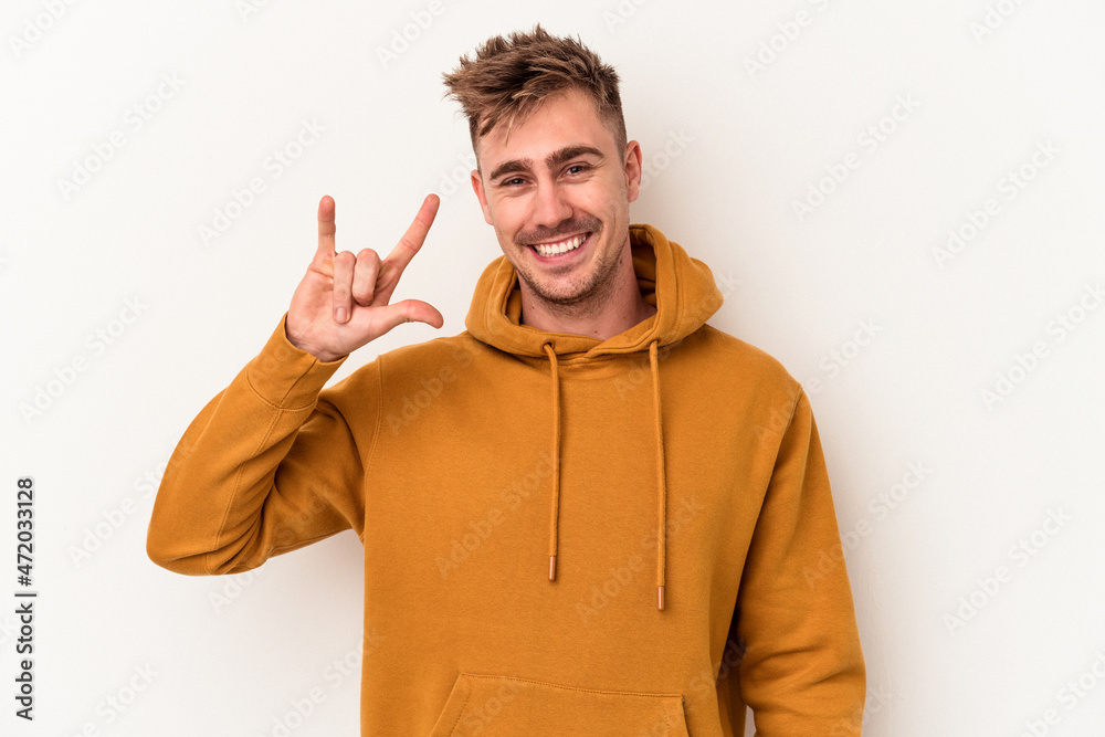Young caucasian man isolated on white background showing a horns gesture as a revolution concept. Young caucasian man isolated on white background showing a horns gesture as a revolution concept.