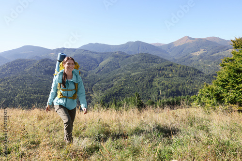 Tourist with backpack walking in mountains on sunny day © New Africa
