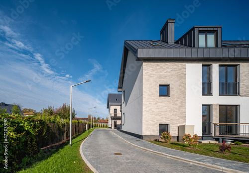 Modern exterior of luxury private cottage. White facade. Green lawn.