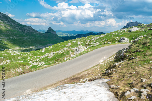 Scenic mountain road with a snowdrift in the foreground. Durmitor National Park. Montenegro. photo