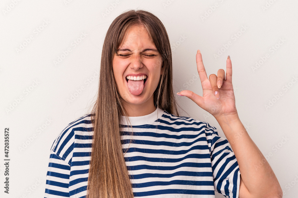 Young caucasian woman isolated on white background showing rock gesture with fingers Young caucasian woman isolated on white background showing rock gesture with fingers