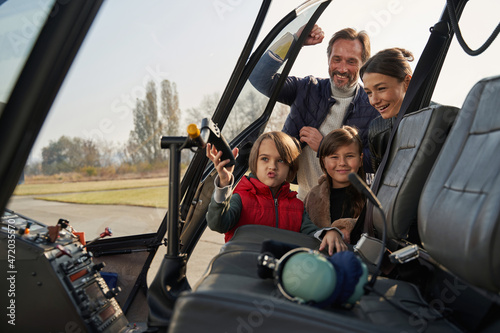 Excited family hanging out together near helicopter