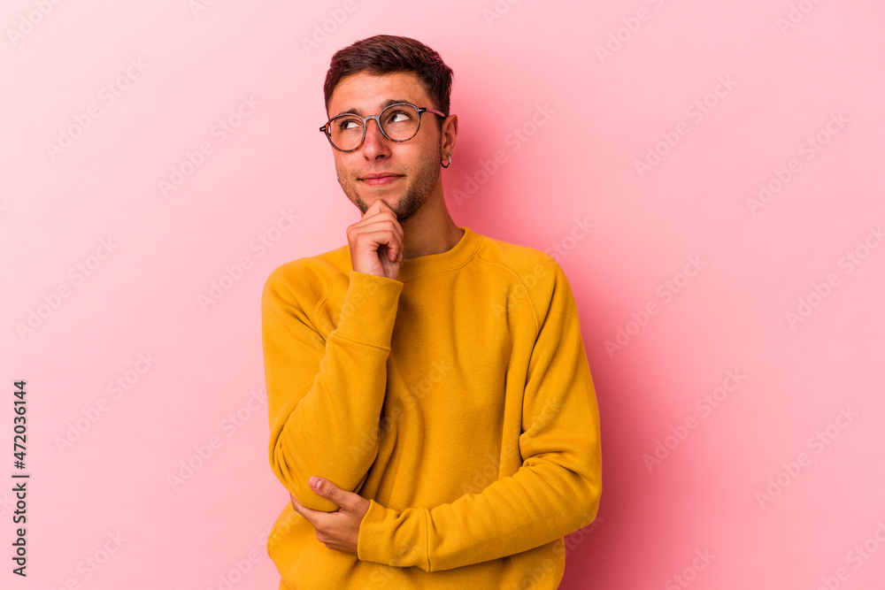 Fototapeta premium Young caucasian man with tattoos isolated on yellow background thinking and looking up, being reflective, contemplating, having a fantasy.