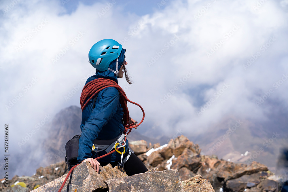 Obraz premium Girl is climbing the summit of the mountain.