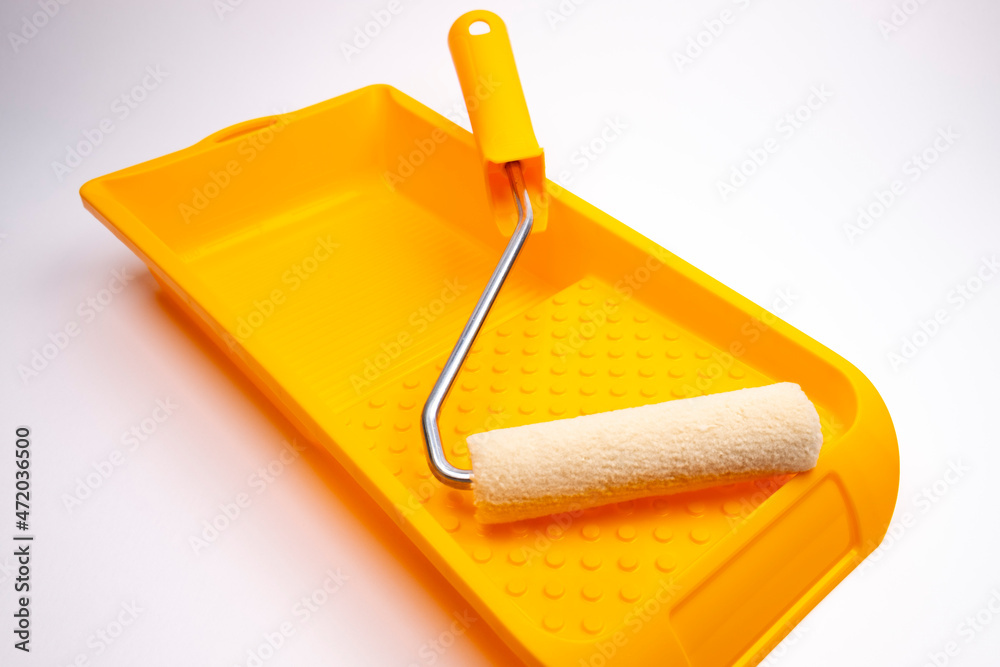 Obraz premium Paint roller and paint tray on a white background 