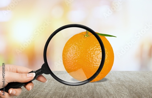 Fresh orange under a magnifying glass. Anti-cellulite creative concept. photo