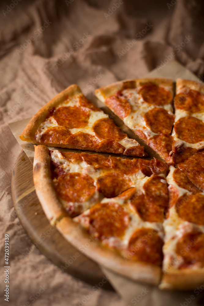 Delicious, aromatic, hot pepperoni pizza on brown background Delicious, aromatic, hot pepperoni pizza on brown background