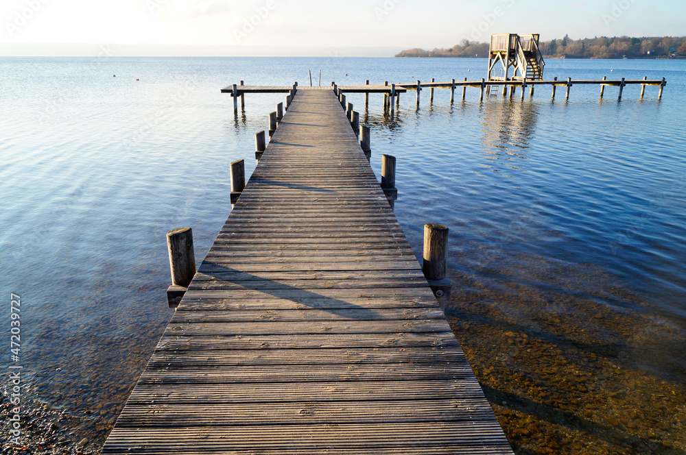 a long wooden pier in Herrsching on Lake Ammersee in Bavaria on a clear December day (Germany)	