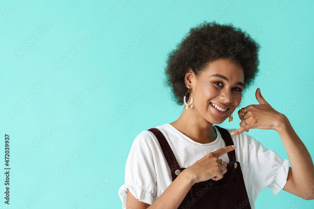 Black young woman pointing finger at her handset gesture Black young woman pointing finger at her handset gesture