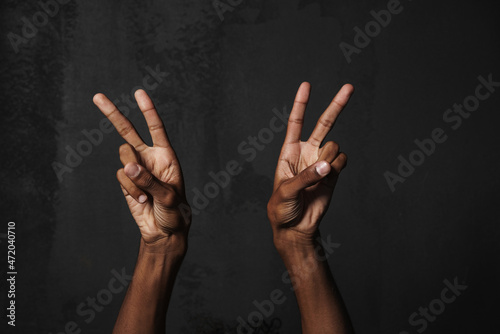 Black man's hands showing peace gesture at camera © Drobot Dean