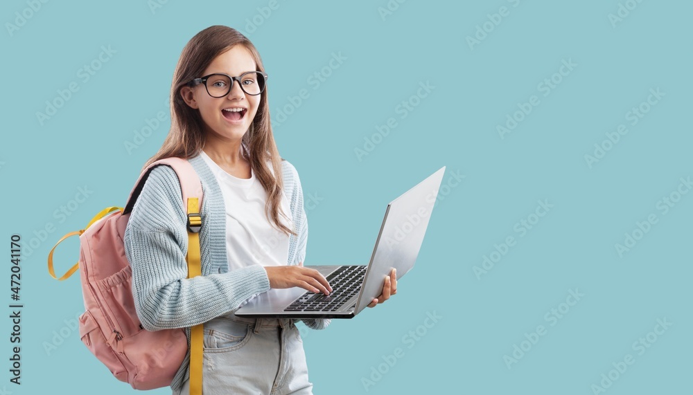 Portrait of smiling teen girl using a laptop computer, studying online Portrait of smiling teen girl using a laptop computer, studying online