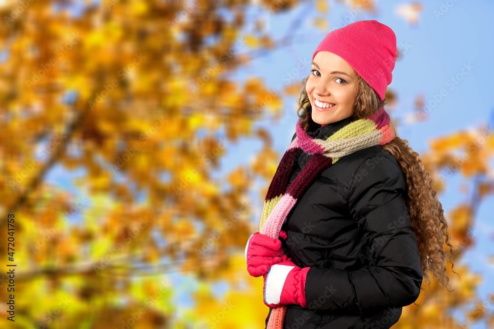 Carefree young woman wearing scarf at park during autumn season. Carefree young woman wearing scarf at park during autumn season.