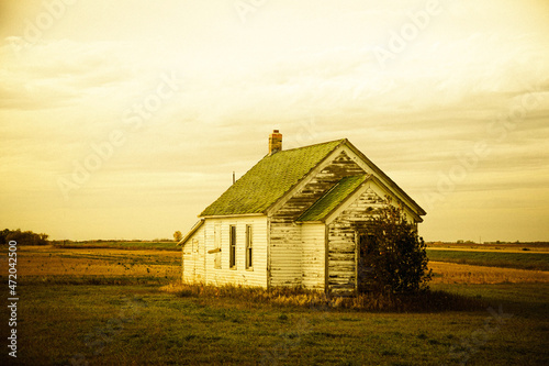 An old, abandoned house sitting in the middle of the great plains of North Dakota.