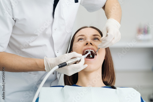 Overview of dental caries prevention, Girl at the dentist chair during a dental scaling procedure, Healthy Smile.