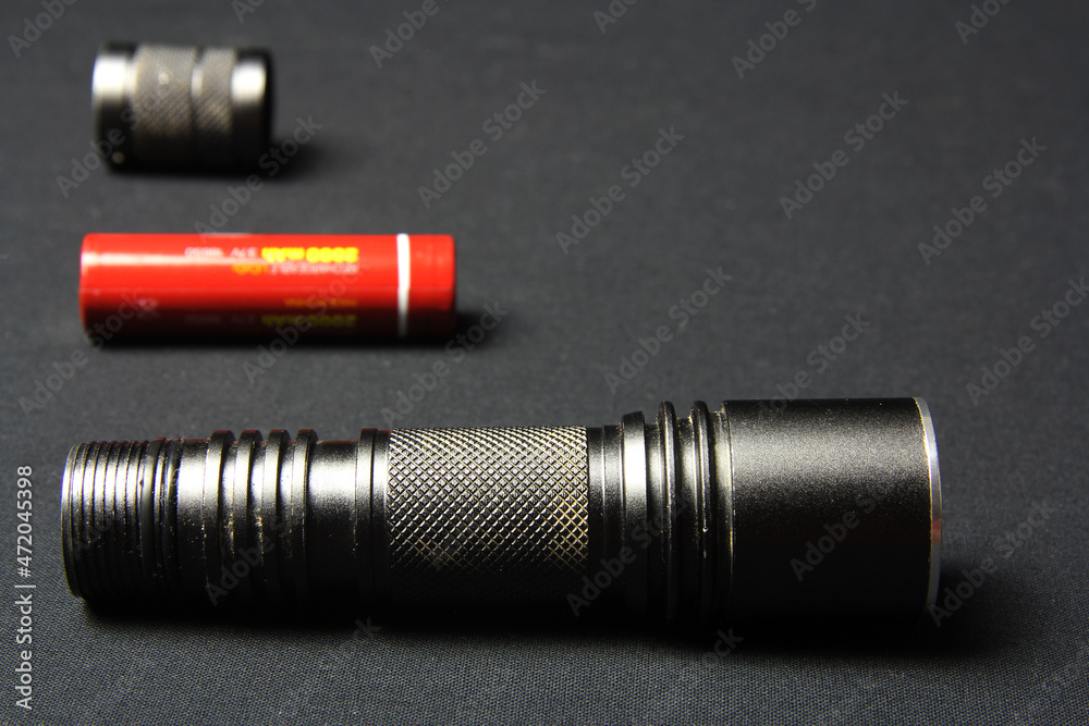 Flashlight on a gray background. Handheld pocket torch for men Flashlight on a gray background. Handheld pocket torch for men