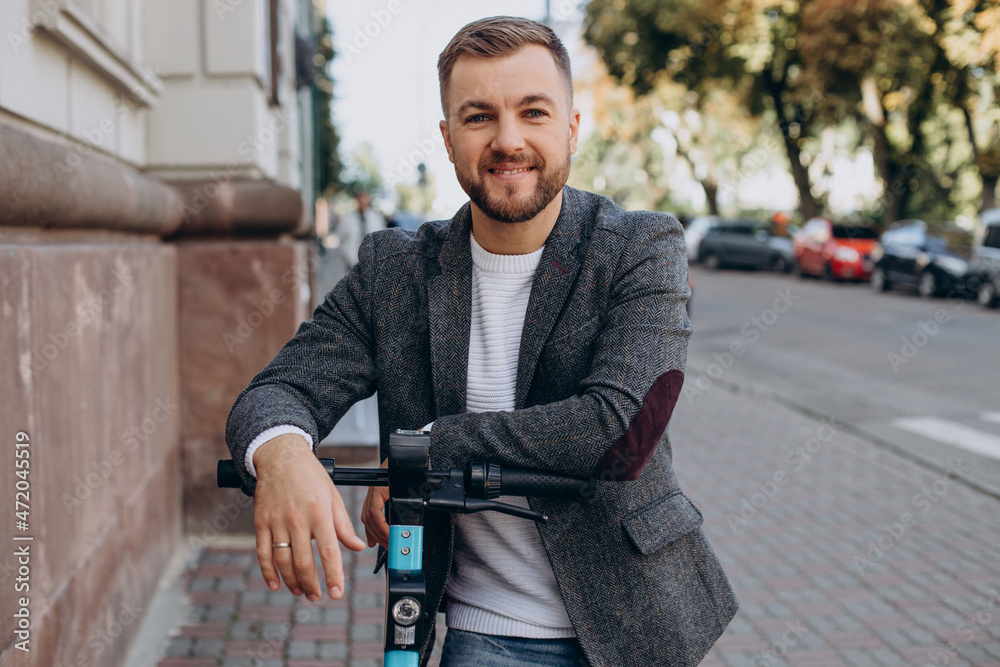 Obraz premium Young man riding electric scooter in town