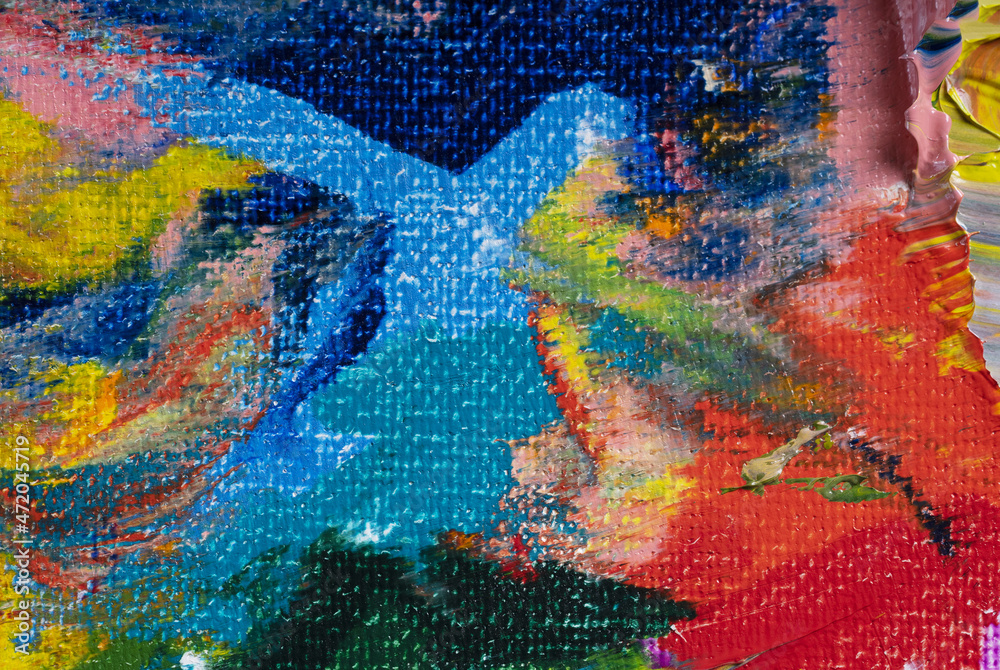 Different bright colors of oil paints are mixed on a palette close-up.