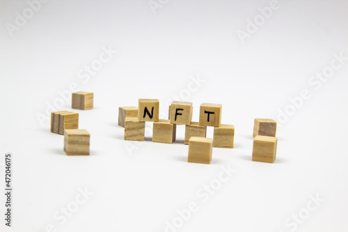 Word NFT  non fungible token  written on the wood cubes on white  background. Non-fungible tokens  concept NFT.