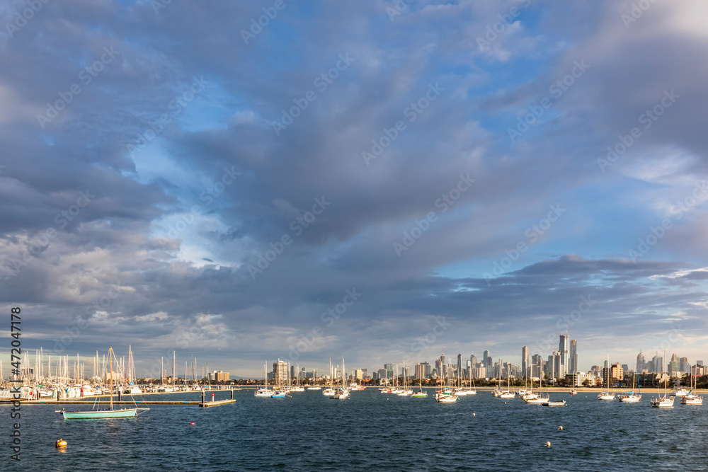 Australia, Victoria, Melbourne, Gray clouds over coastal city with boats floating in foreground Australia, Victoria, Melbourne, Gray clouds over coastal city with boats floating in foreground