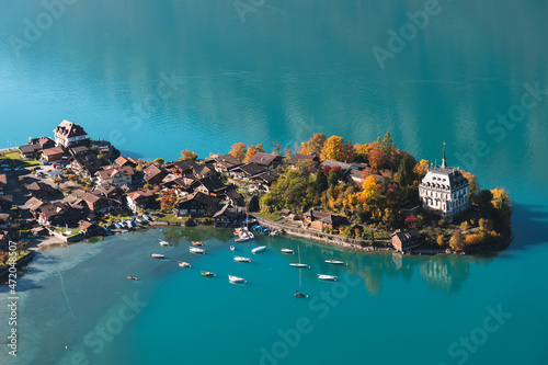 Boats by island on water at Iseltwald, Interlaken, Switzerland photo