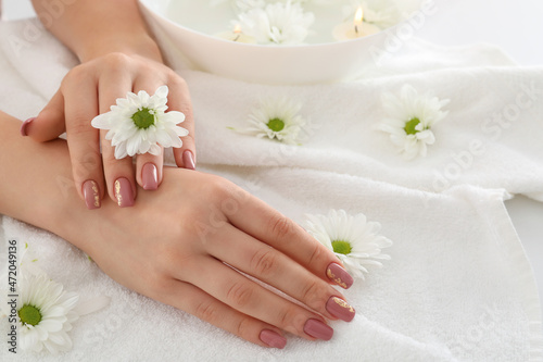 Concept of hand care with cosmetics on white towel background