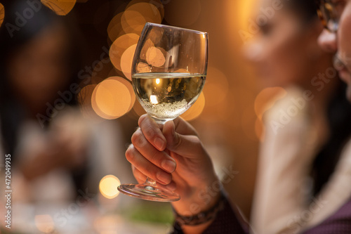 holidays, party and celebration concept - close up of man having christmas dinner at home and drinking white wine
