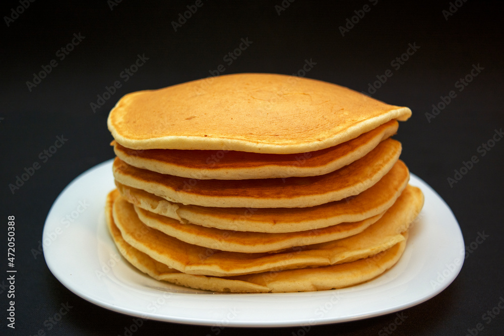 Piled up sweet, delicious pancakes on a white plate Piled up sweet, delicious pancakes on a white plate