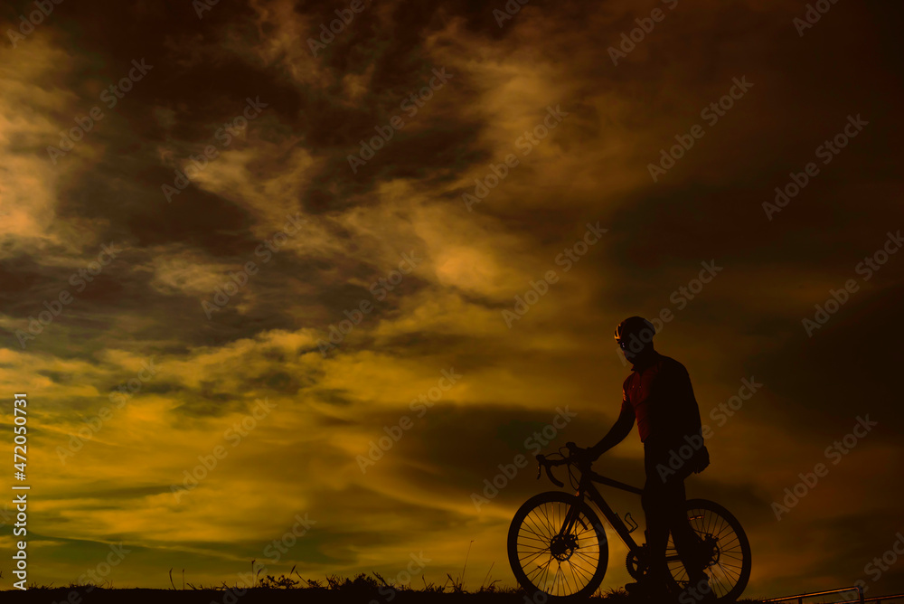 Obraz premium Silhouette of handsome man riding bicycle on sunset,sport man concept,Fill flare effect