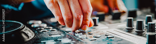 Fotografie DJ Hands creating and regulating music on dj console mixer in concert nightclub