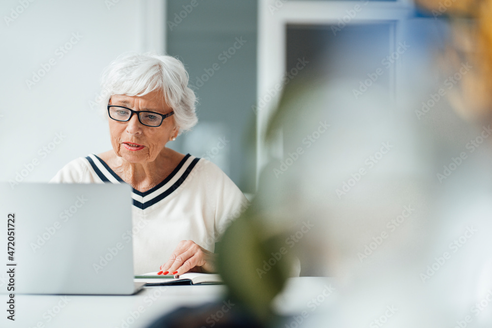 Woman with eyeglasses using laptop at home