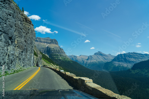 View from Going to the Sun Road near Logan Pass in Glacier National Park, Montana on a sunny summer day, with glacial valley, snow-capped mountains, alpine lakes, and grass photo