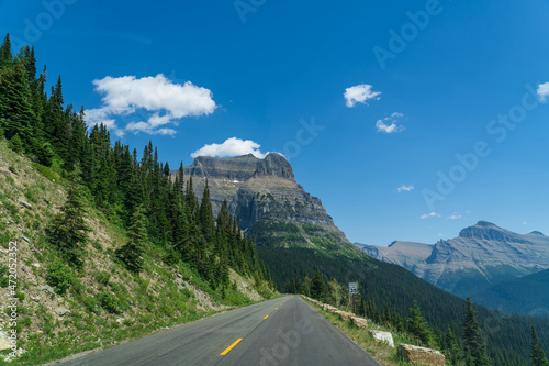 Fototapeta Naklejka Na Ścianę i Meble -  View from Going to the Sun Road near Logan Pass in Glacier National Park, Montana on a sunny summer day, with glacial valley, snow-capped mountains, alpine lakes, and grass